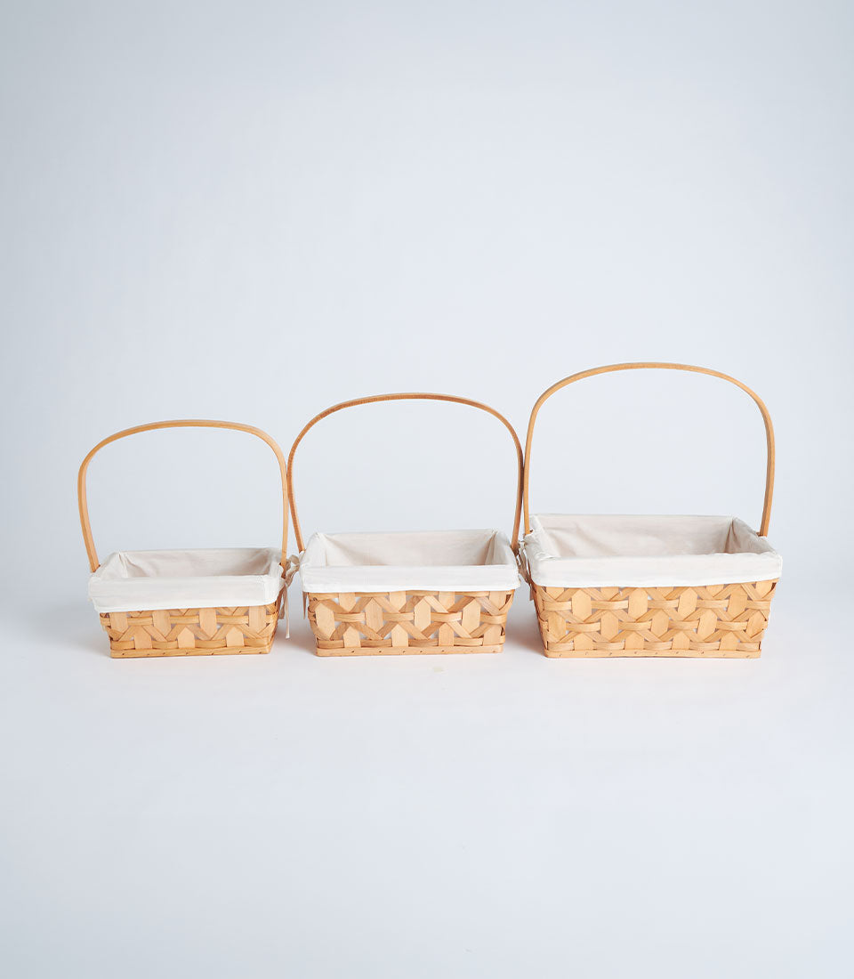 Handwoven rectangular wicker baskets in natural wood with fabric liners and curved handles