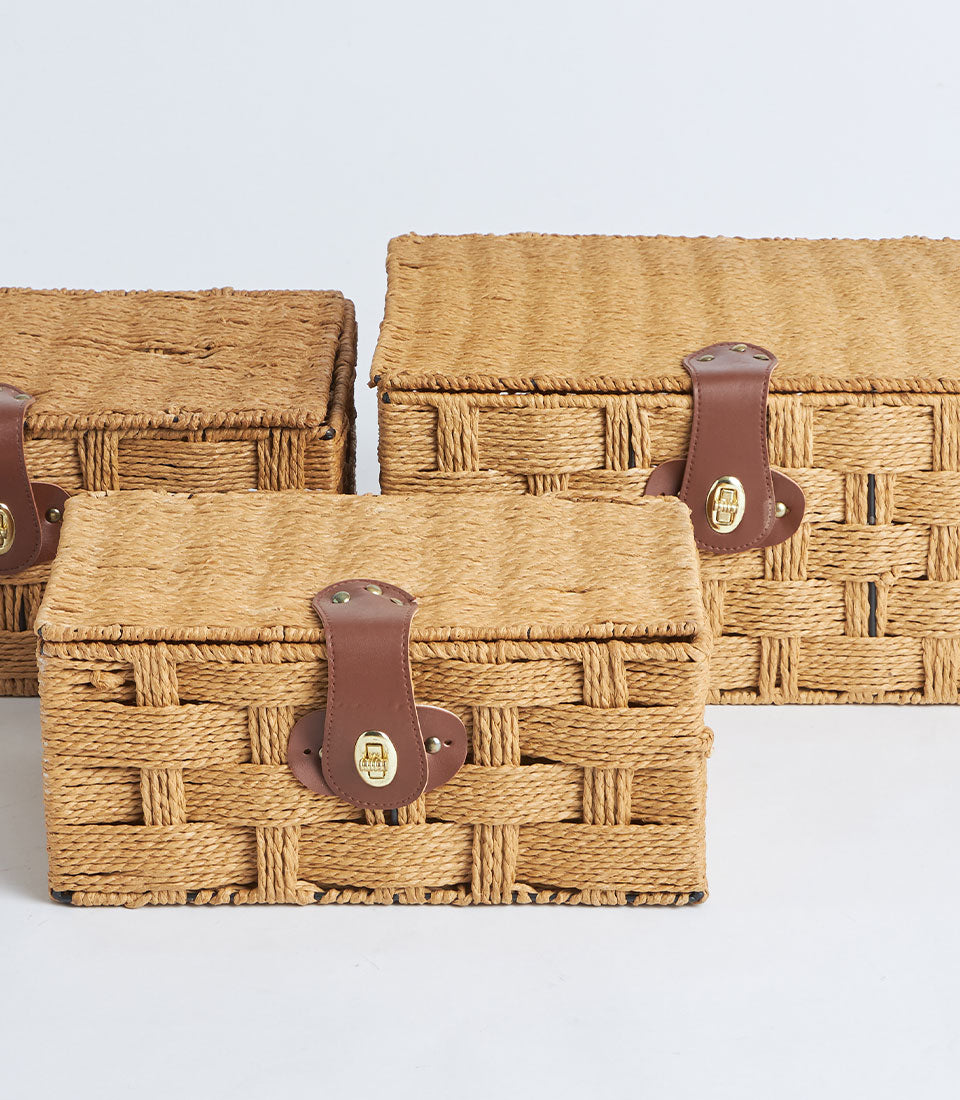 Nested woven storage baskets with leather locks in natural raffia, set of three sizes