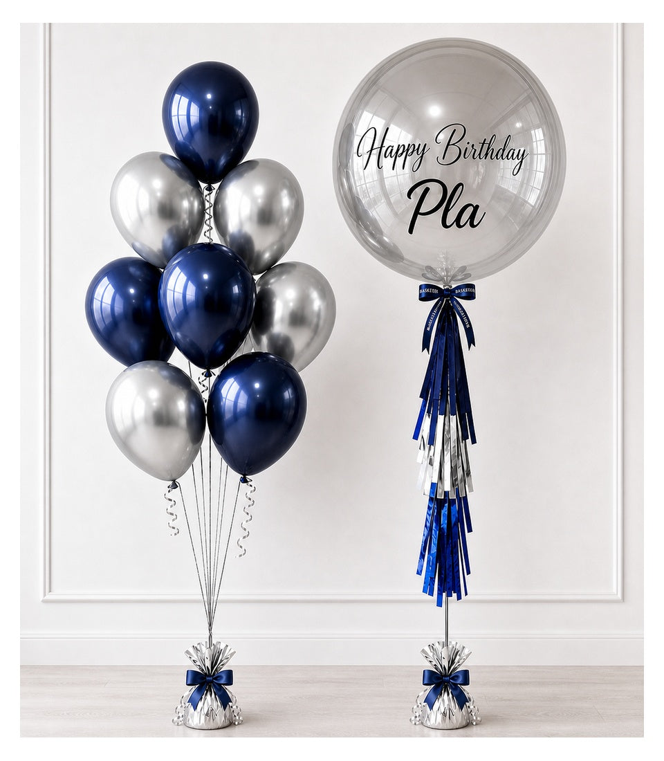 Navy blue and silver balloon bouquet with a personalized clear bubble balloon displaying "Happy Birthday Pla" text and blue ribbon tassels.