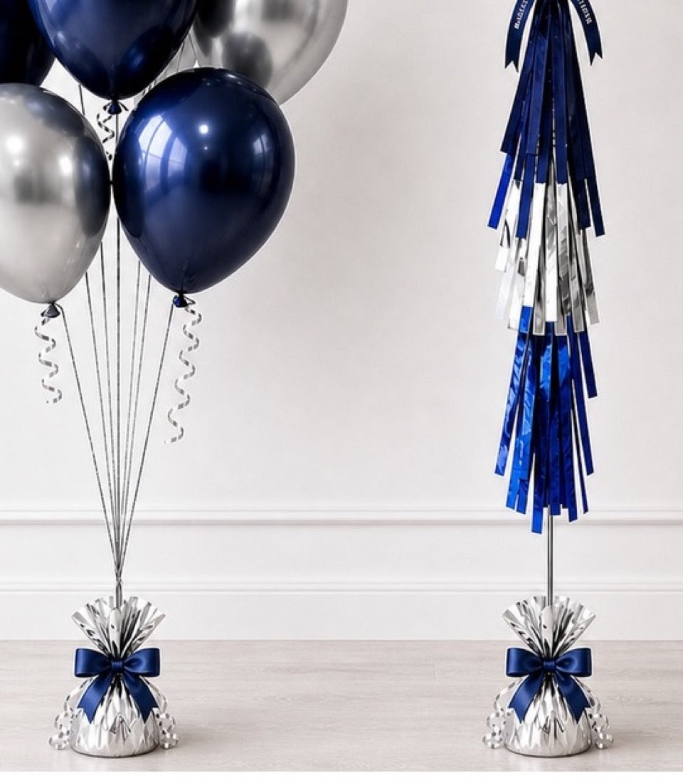 Navy and silver balloons with matching tassel garland and ribbon-tied base weights on white background.