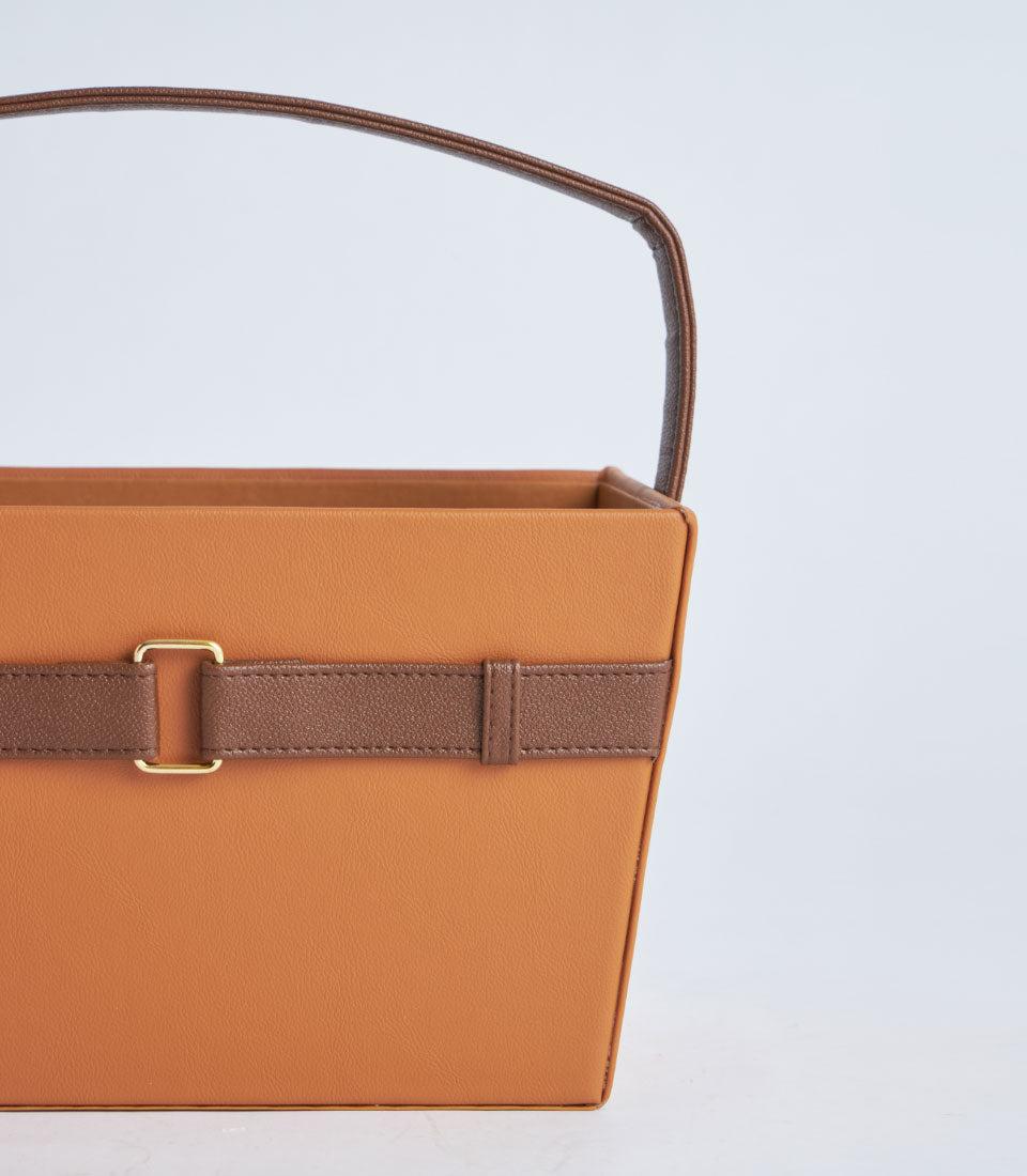 Tan leather gift basket with dark brown handle strap and gold buckle closure