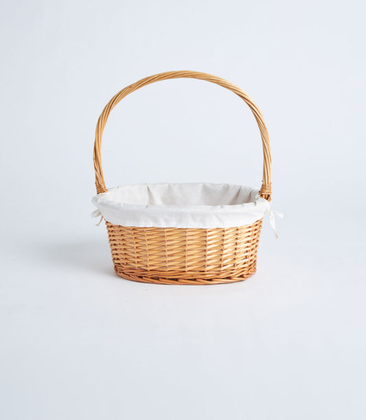 Natural wicker oval gift basket with cream fabric lining and arched handle