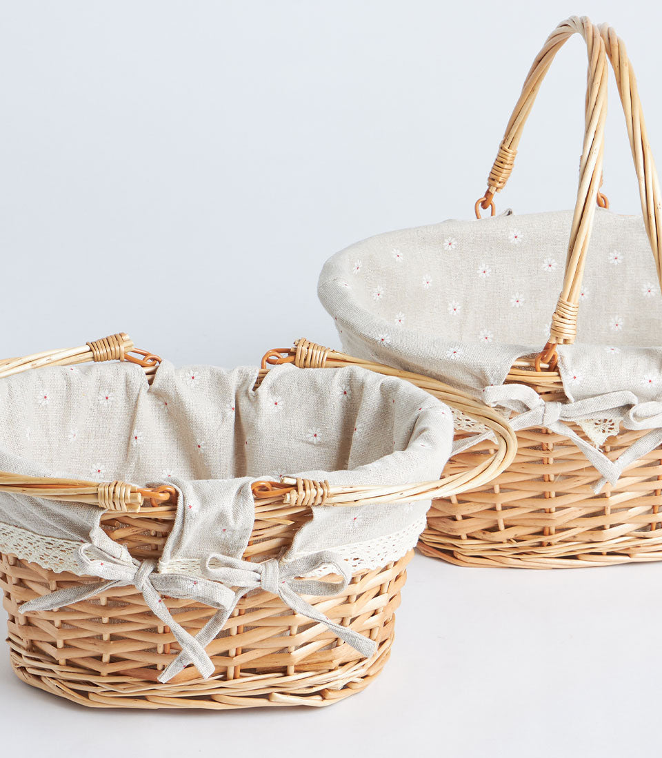 Handwoven oval wicker baskets with fabric lining and double handles for luxury gift hampers