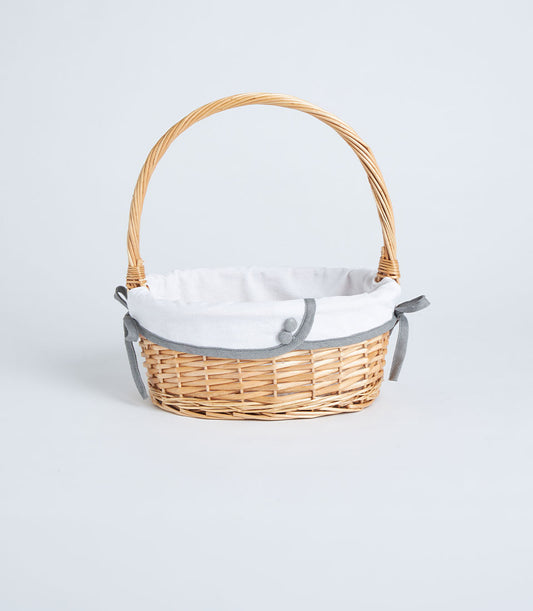 Light brown handwoven wicker basket with white fabric liner and grey ribbon ties