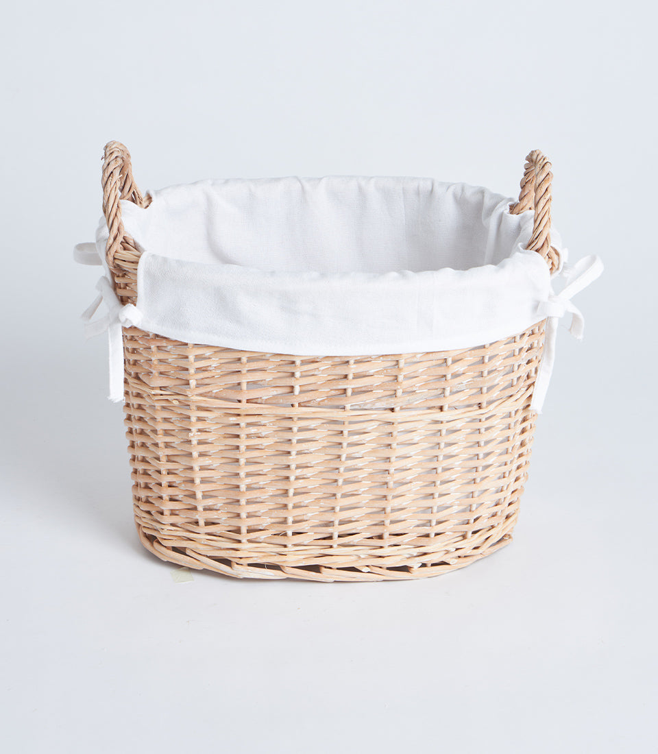 Handwoven oval wicker basket with white fabric liner and braided side handles