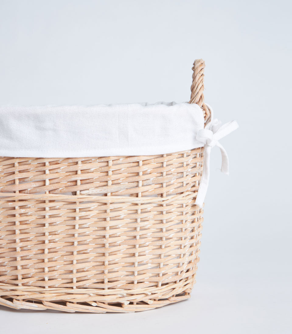 Light woven wicker basket with white fabric liner and braided handles for premium gift hampers