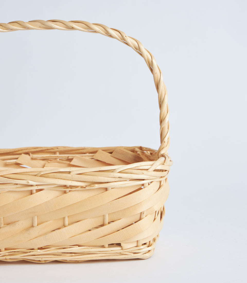 Natural wicker rectangular basket with braided handle and wood shavings for premium gift curation