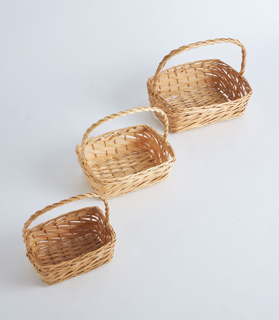 Light natural bamboo woven baskets with twisted handles in three graduated sizes