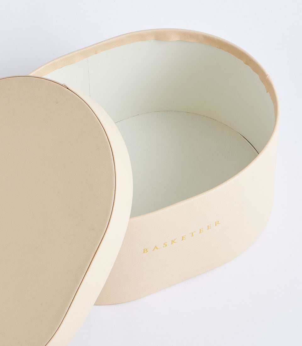 Beige leather storage box with gold-embossed Basketeer branding and cream interior lining
