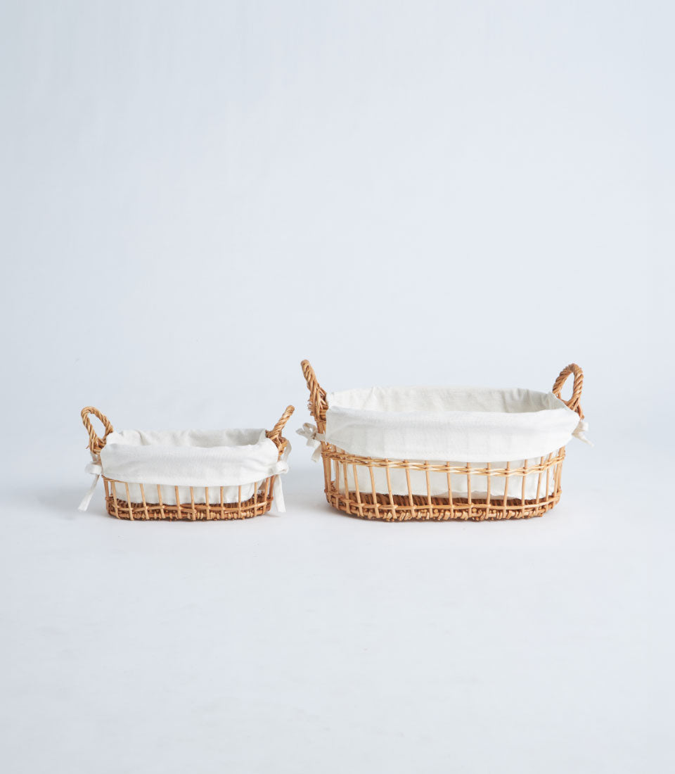 Light brown woven rattan gift baskets with white fabric liners and rope handles, ready for curated gifting