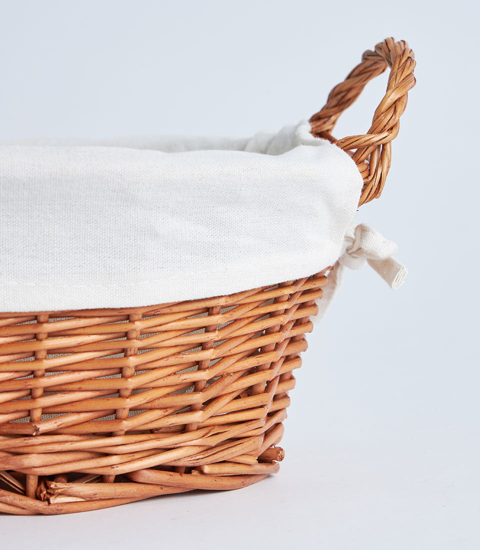 Natural woven wicker basket with white linen lining and braided handles