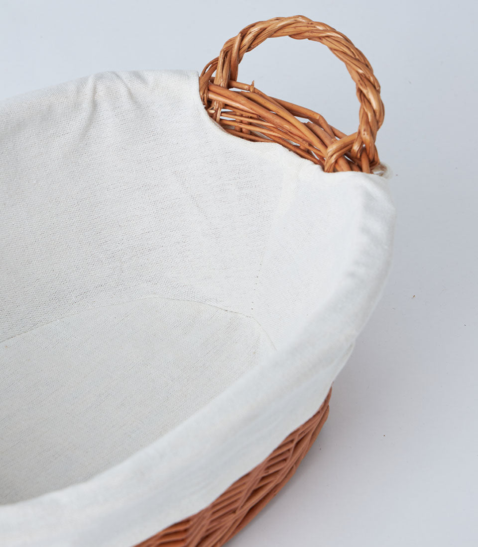 Natural wicker basket with white linen lining and braided handle