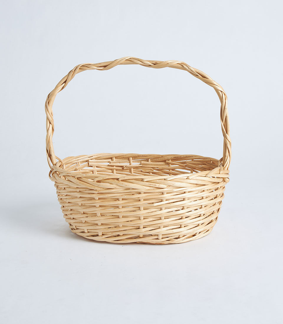 Natural woven wicker oval basket with twisted handle, light tan rattan craft