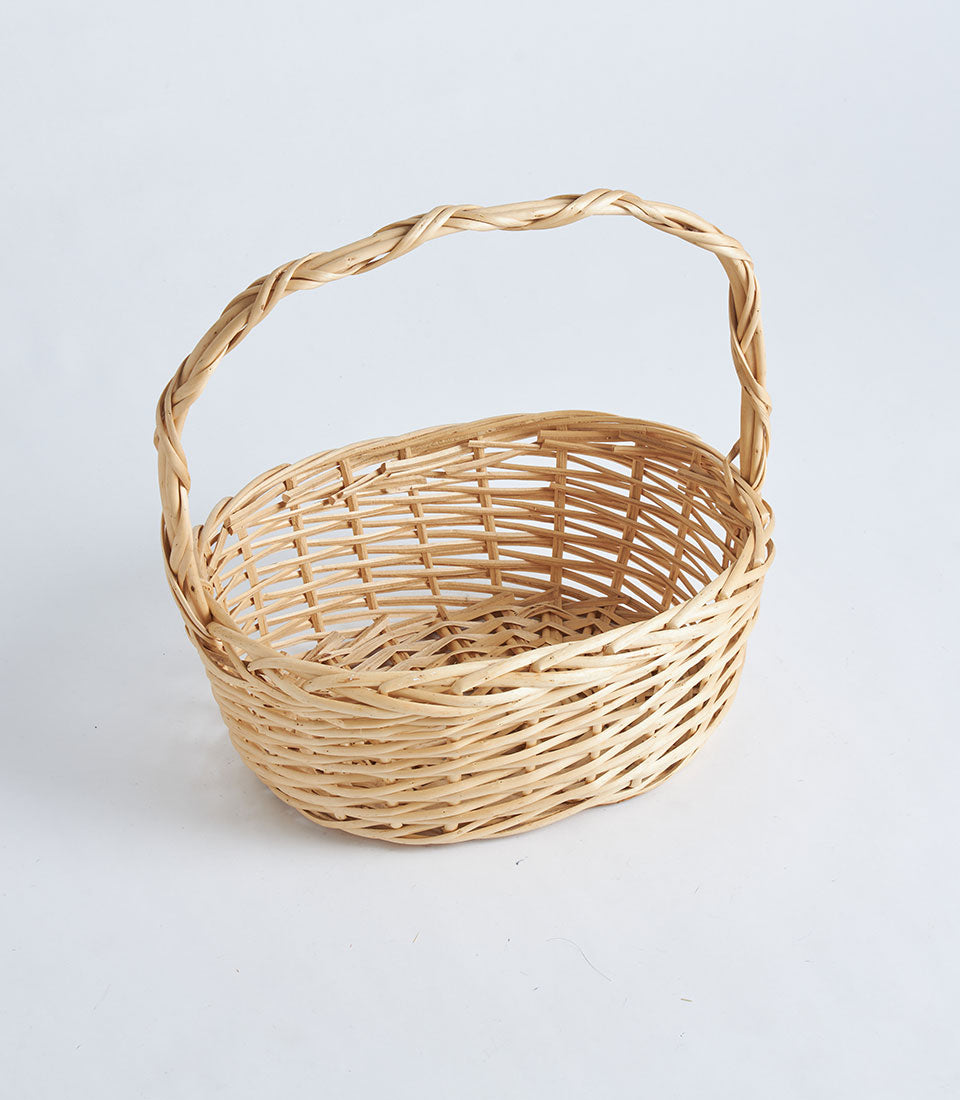 Natural wicker oval basket with twisted handle, light tan handwoven rattan