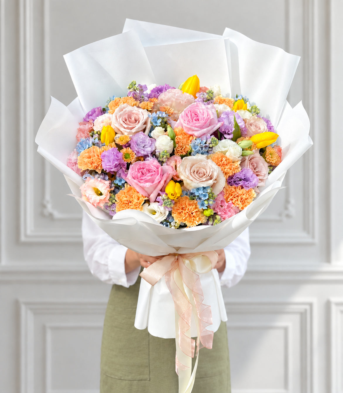 Full front studio view of pastel mixed rose tulip and carnation bouquet
