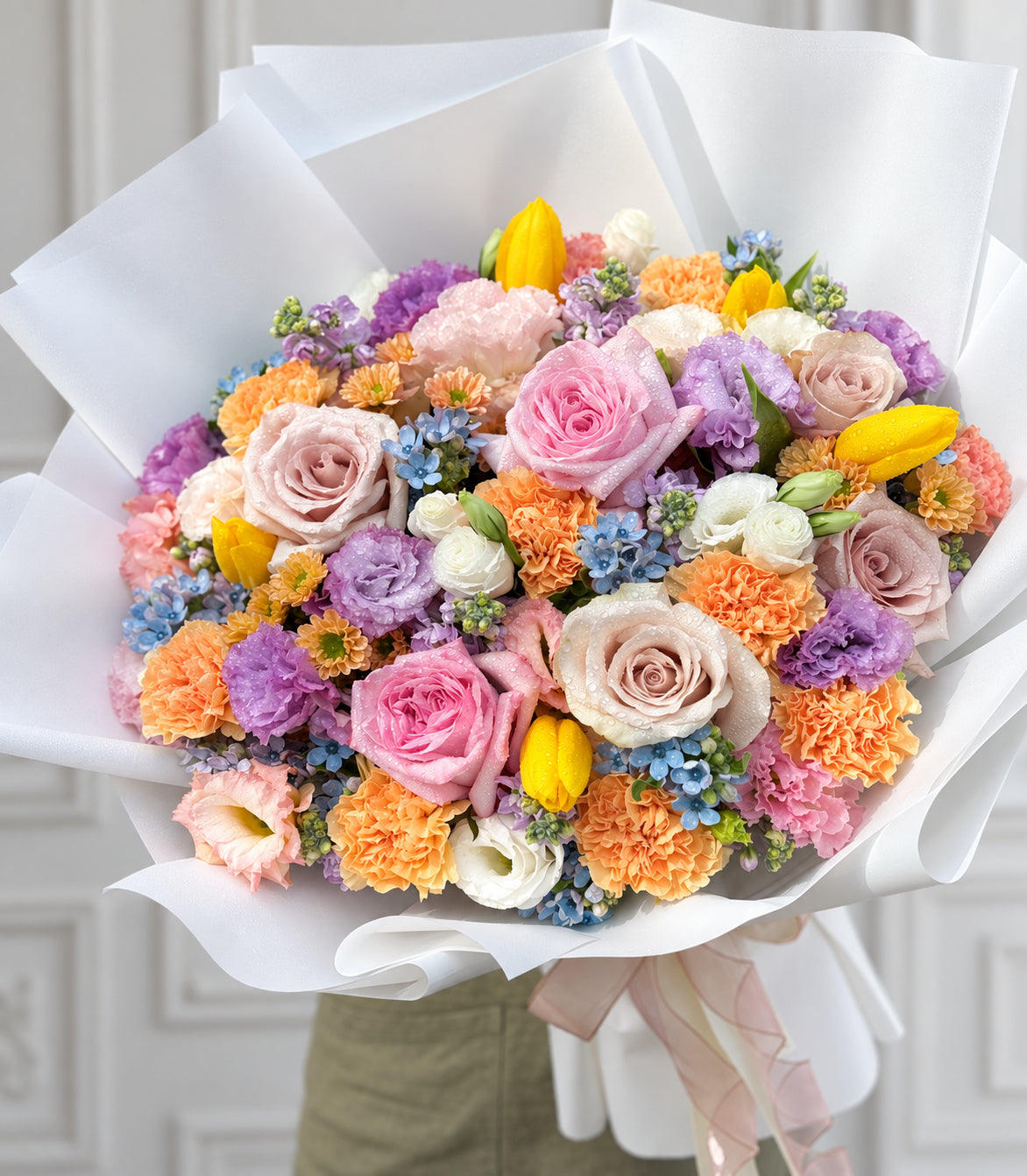 Close-up of roses, yellow tulips, carnations and lilac flowers