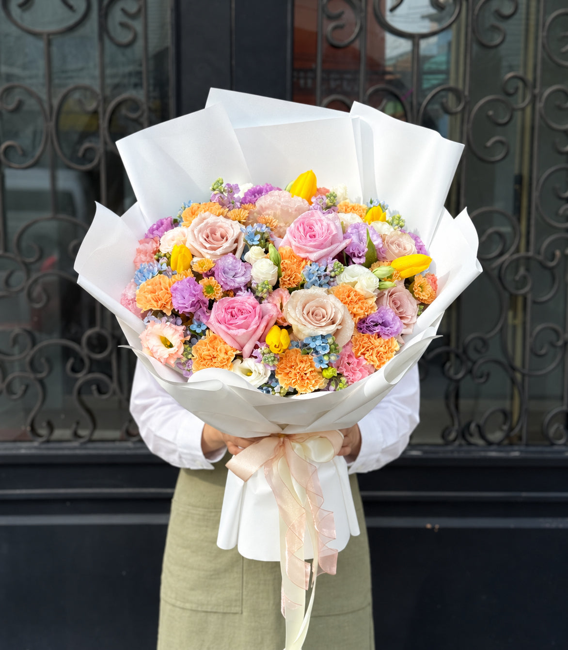 Full outdoor view of pastel rose tulip and carnation bouquet