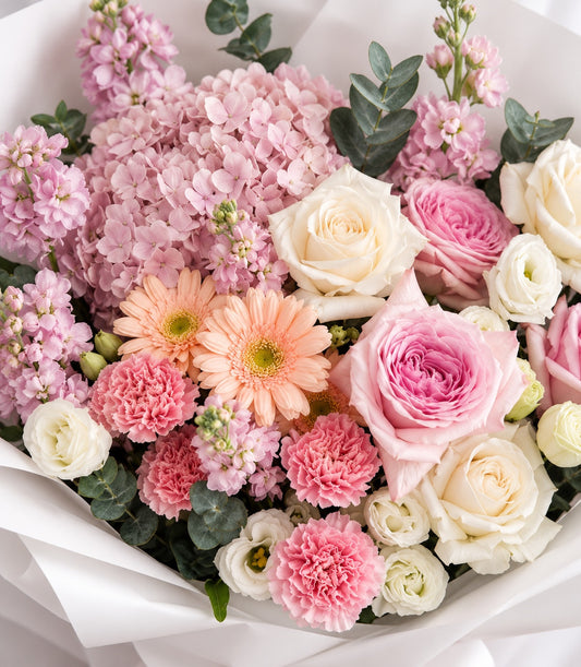 A luxurious blush pink and ivory rose bouquet with peach gerberas, pink