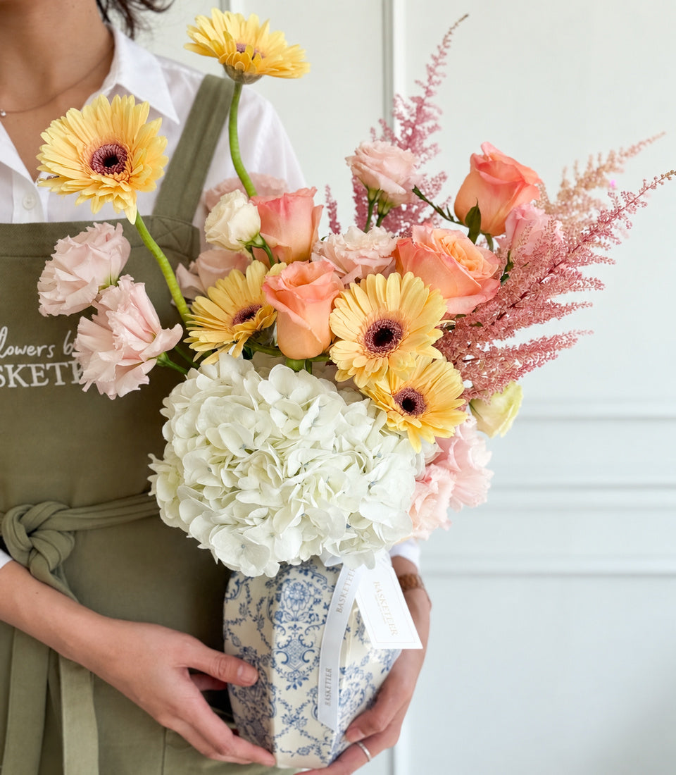 An elegant Flowers by Basketeer vase arrangement with white hydrangeas, peach roses