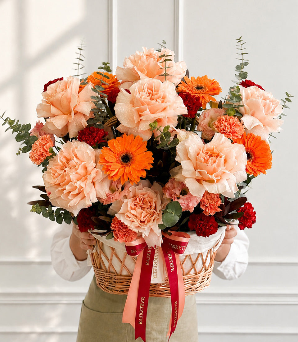 Luxurious mixed floral basket from Flowers by Basketeer, featuring vibrant peach carn
