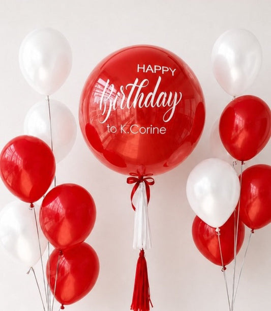 Red and white balloon bouquet with large personalized red bubble balloon reading "Happy Birthday to K.Corine" and red tassels.