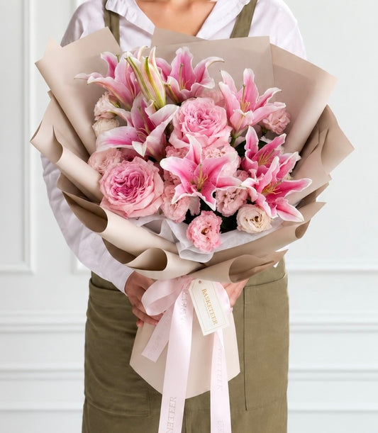 Luxurious pink O'Hara rose and stargazer lily bouquet wrapped in natural