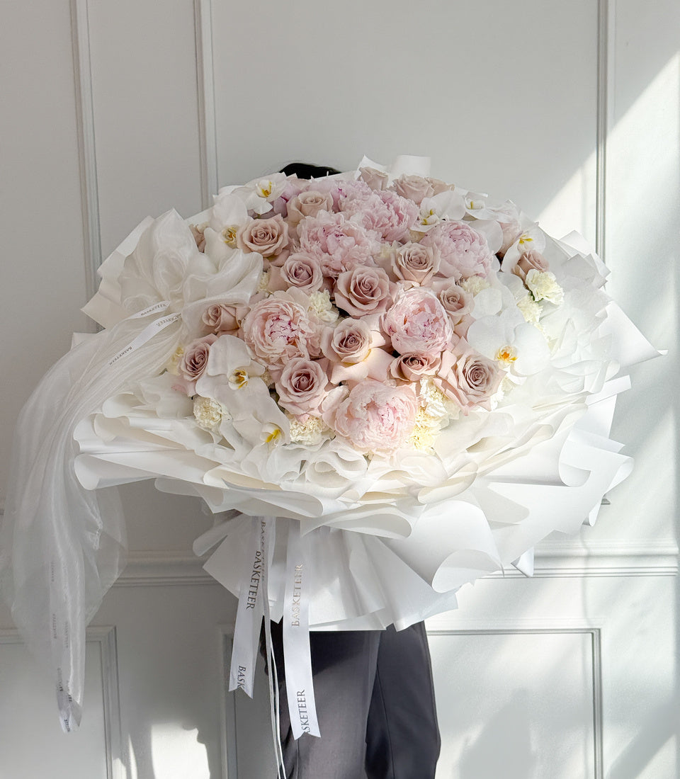 Full front view of luxury pink peony rose and white orchid bouquet