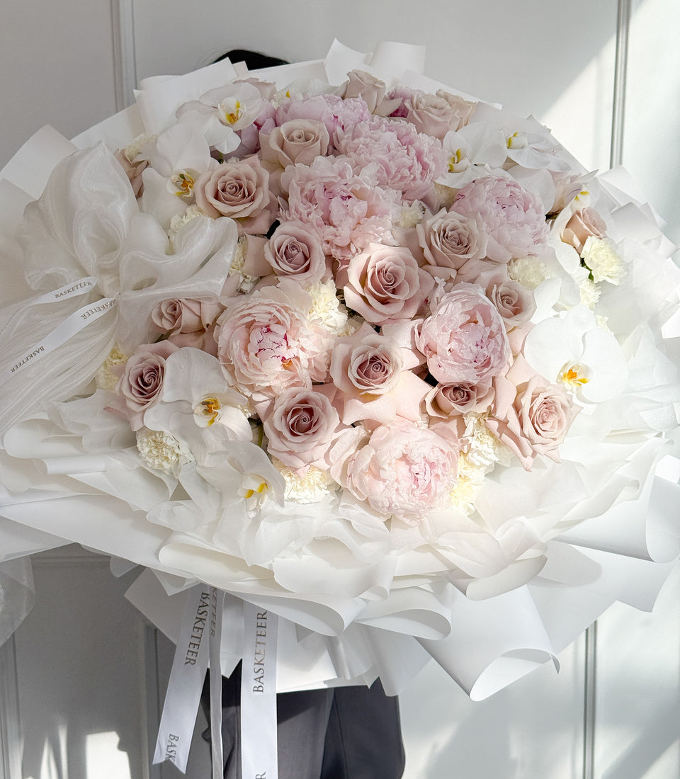 Model-held front view of grand pink peony rose orchid bouquet 
