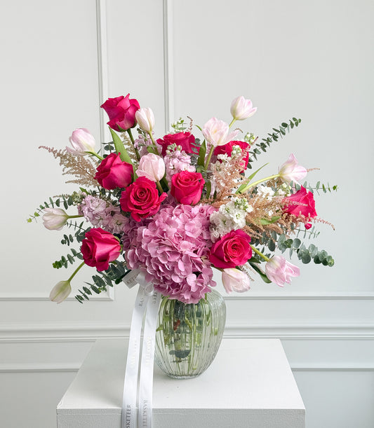 A luxurious Flowers by Basketeer vase arrangement featuring vibrant pink roses, delicate