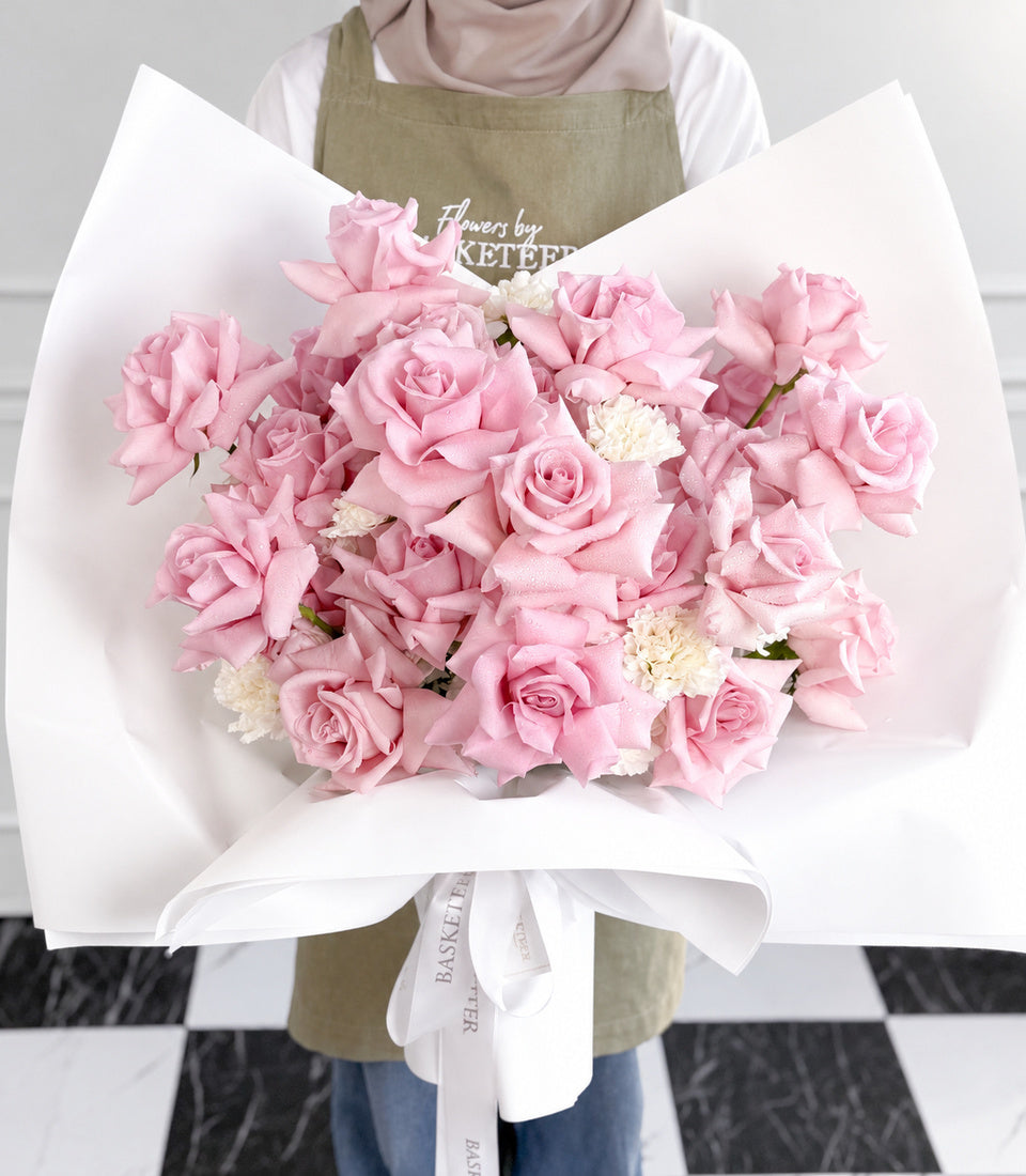 Front close-up of luxury pink rose bouquet in white wrapping
