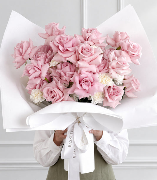 A luxurious Basketeer gift bouquet of abundant pink roses and delicate white filler