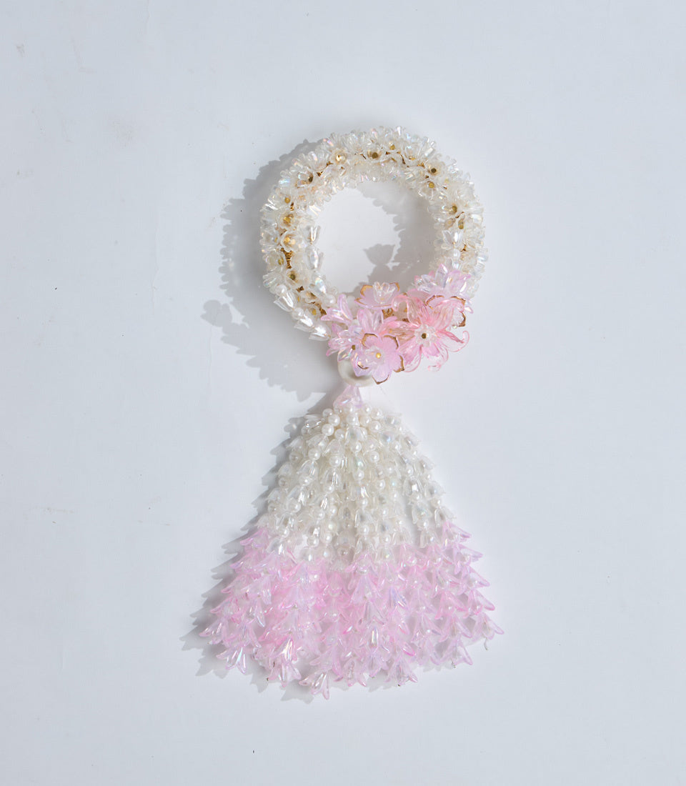 White and pink beaded tassel ornament with circular loop top, featuring crystalline beads in gradient ombre style design.