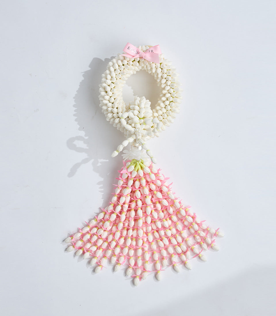 Jasmine flower garland necklace with white blooms and pink accents, featuring a pink ribbon bow at top, traditional Thai style decoration.