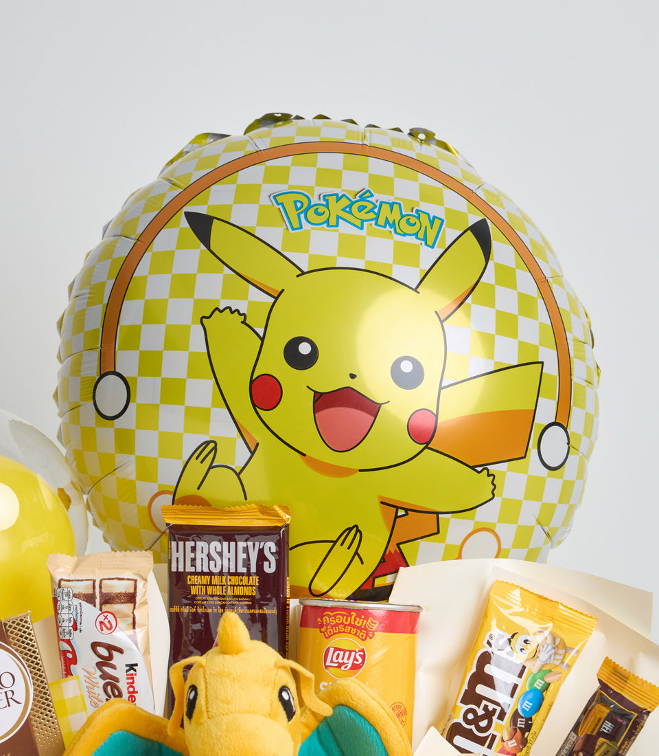 Pokémon Pikachu themed gift set featuring yellow and white checkered balloon, chocolate bar, Lay's chips, snacks, and plush toy.