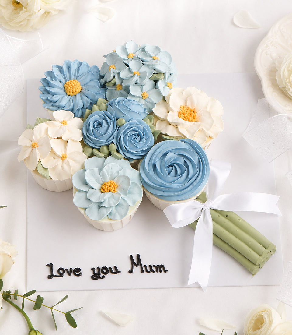 Charlotte Bakery artisan custom cake bouquet featuring delicate blue and white buttercream flowers