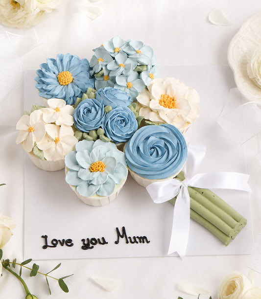 Charlotte Bakery artisan custom cake bouquet featuring delicate blue and white buttercream flowers