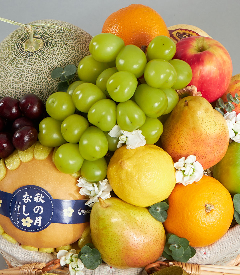 Premium imported fruit basket with cantaloupe, grapes, cherries, pears, apples and citrus in woven presentation basket
