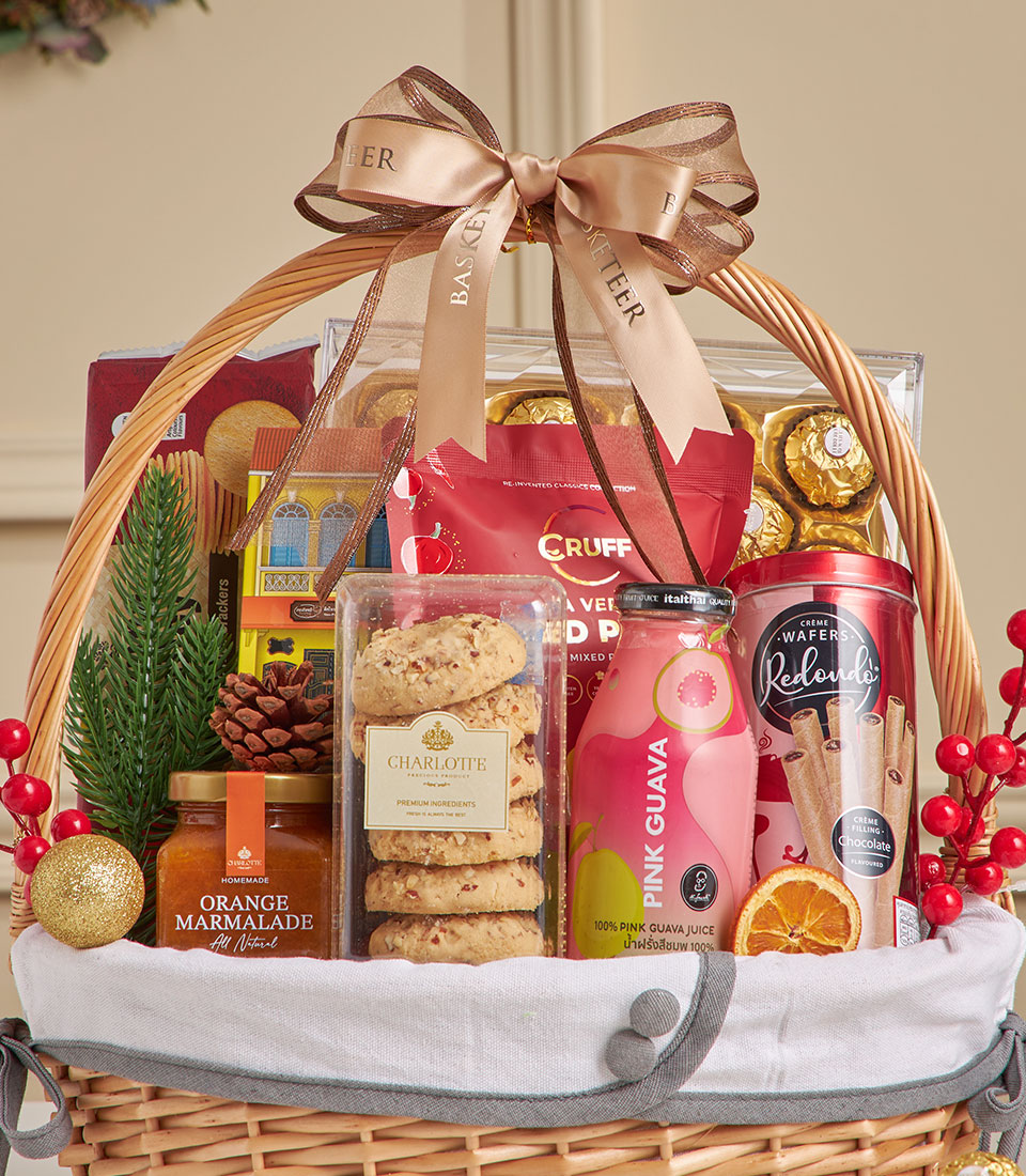 Woven wicker gift basket with spiced guava juice, chocolate wafers, cookies, and gourmet treats tied with gold ribbon, New