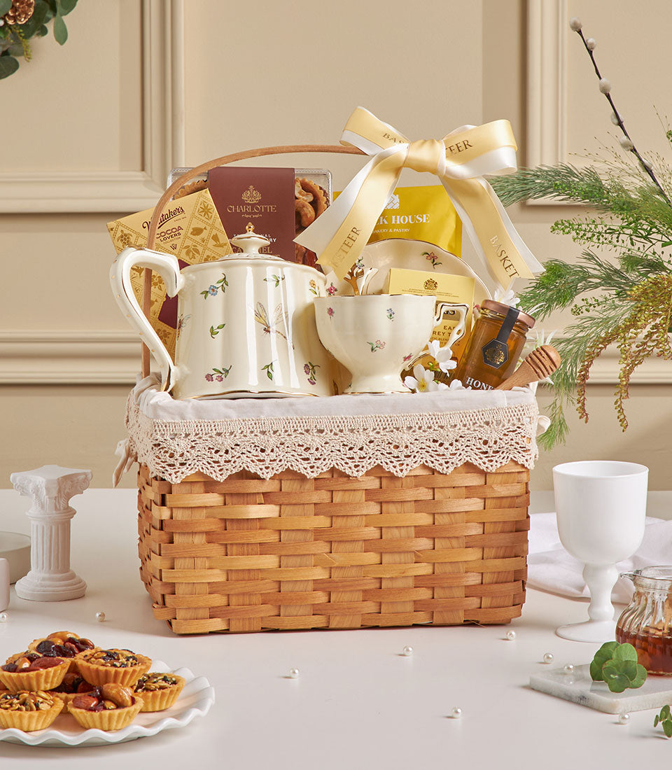Wicker tea time hamper with ceramic teapot, teacup, chocolates, and honey for New Year gifting