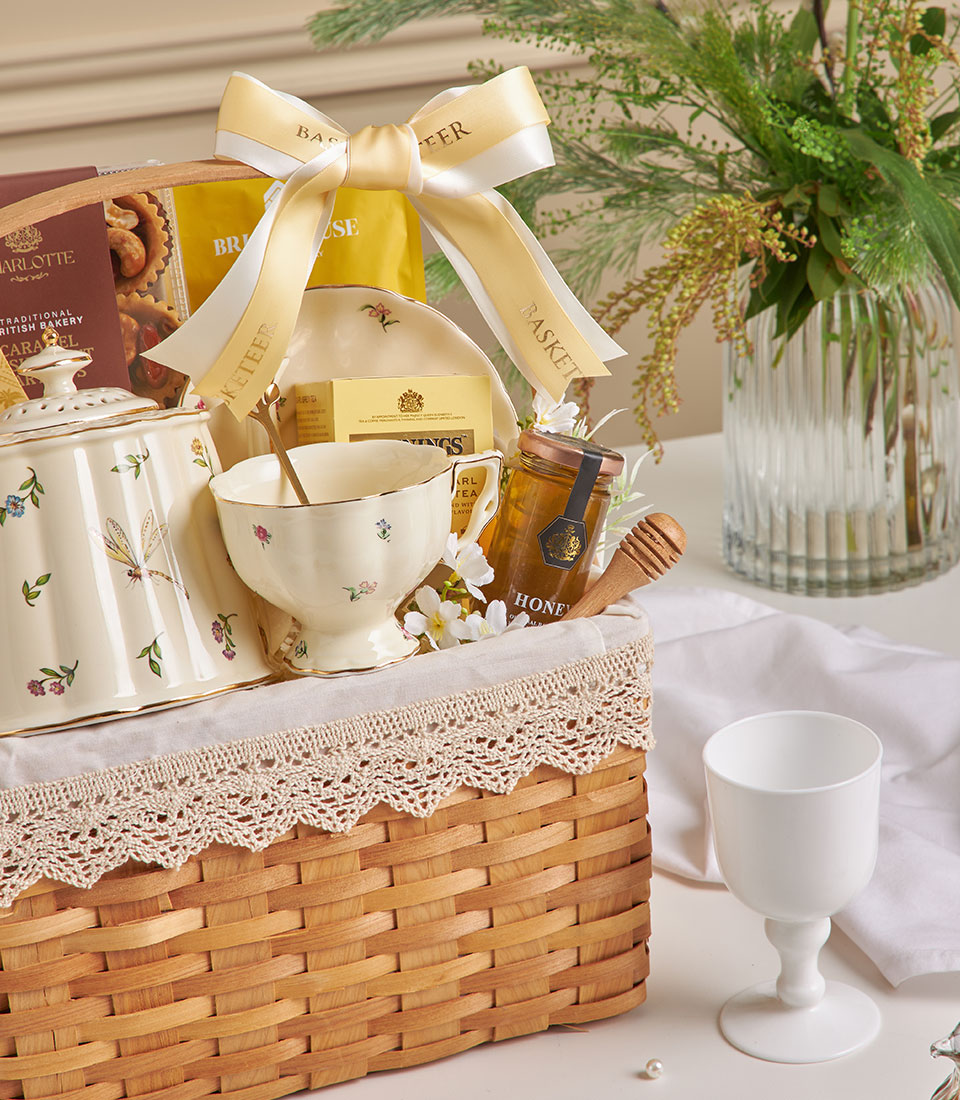 Cream ceramic tea set with Earl Grey and honey in woven gift basket, New Year gift hamper