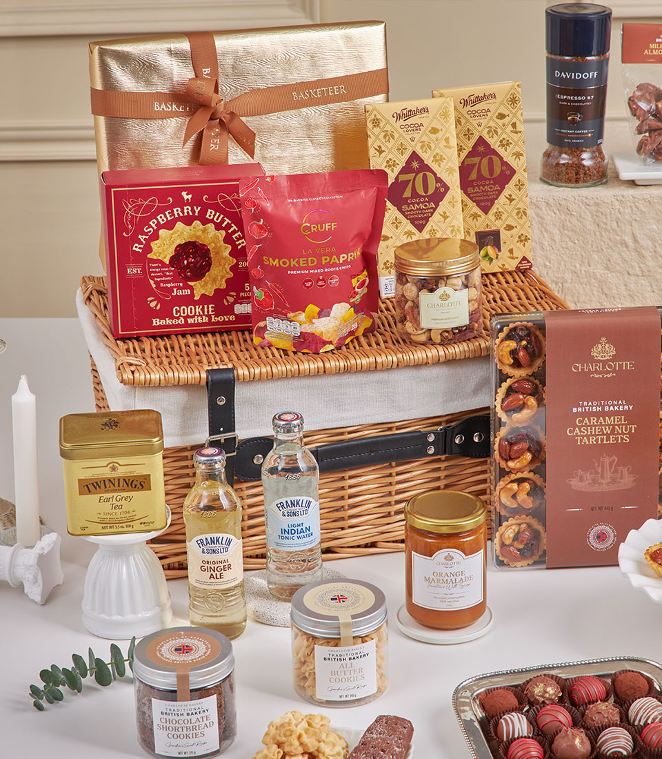Luxury New Year gift hamper with wicker basket, gourmet chocolates, tea, nuts, and festive treats in elegant packaging