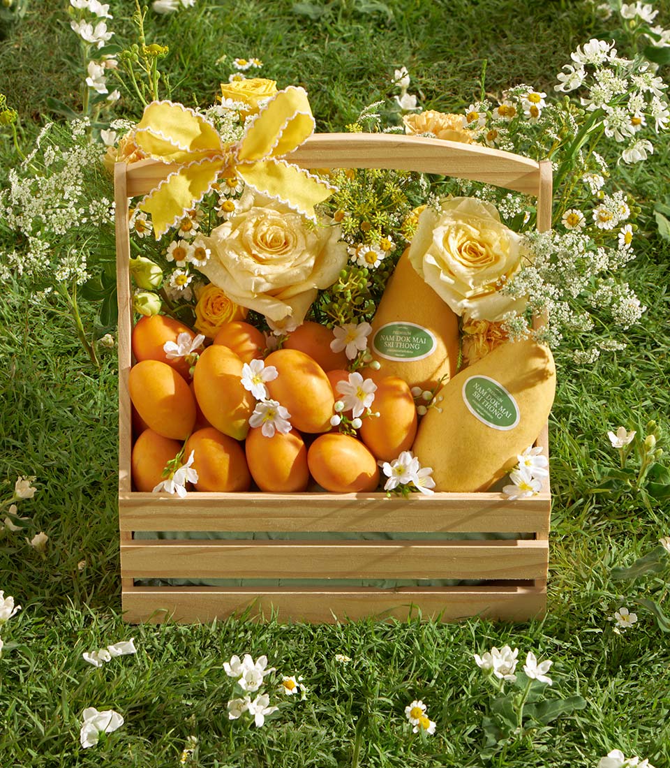Premium wooden basket with fresh Nam Dok Mai mangoes, yellow roses, and white wildflowers for gifting