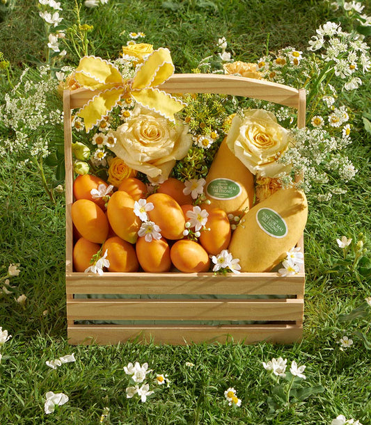 Premium wooden basket with fresh Nam Dok Mai mangoes, yellow roses, and white wildflowers for gifting