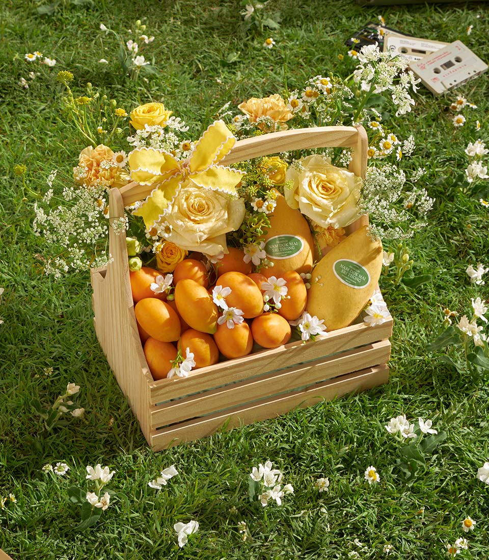 Premium mango and roses wooden basket with fresh tropical fruit and yellow blooms