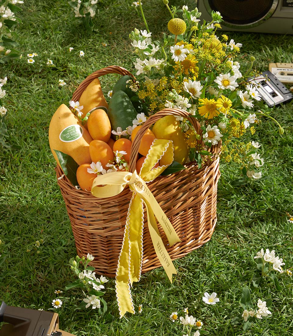 Premium mango and orchid gift basket with fresh flowers and yellow satin ribbon