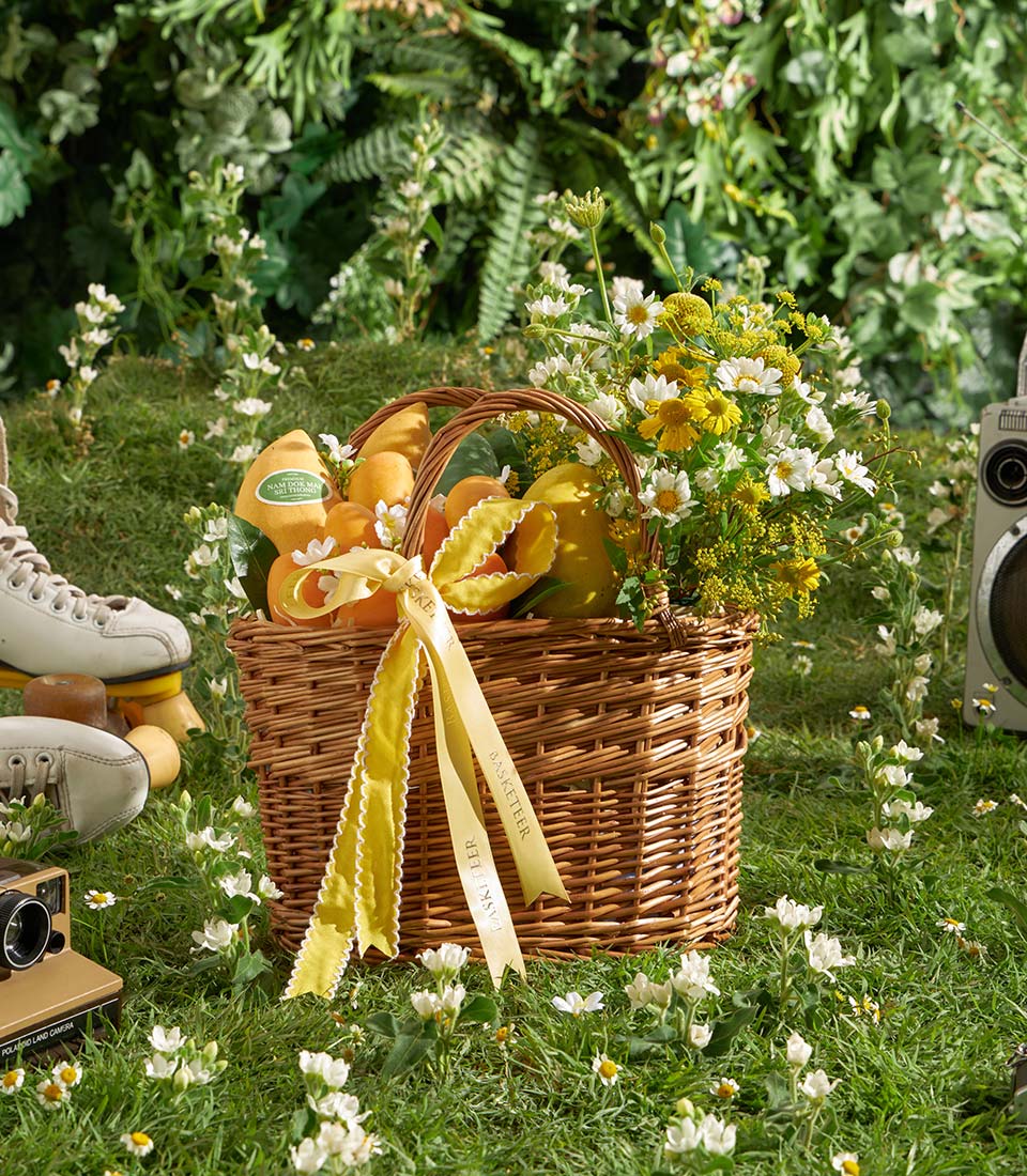 Luxury mango and orchid gift basket with fresh white daisies and yellow flowers, artisan wicker hamper for premium gifting