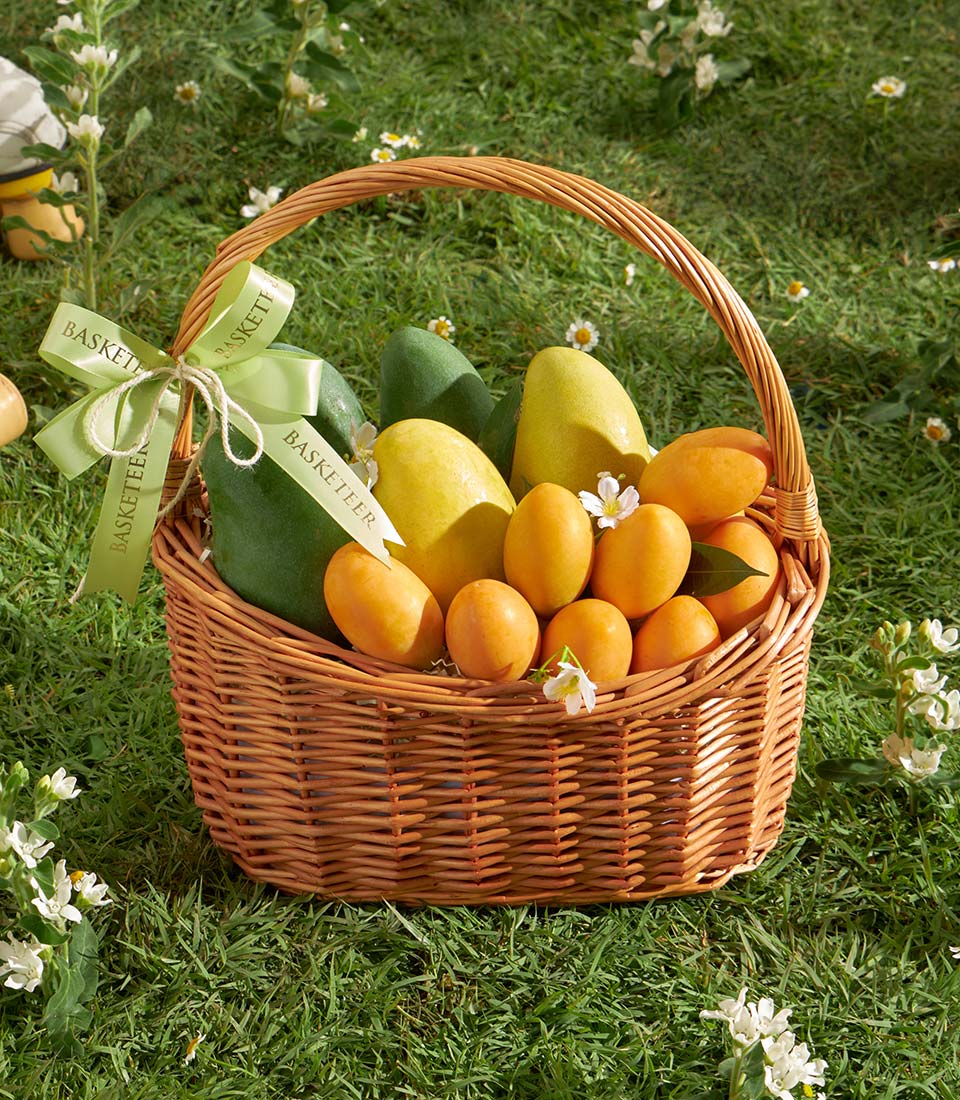 Premium wicker basket with fresh mangoes, mayongchid, and white blossoms tied with green ribbon