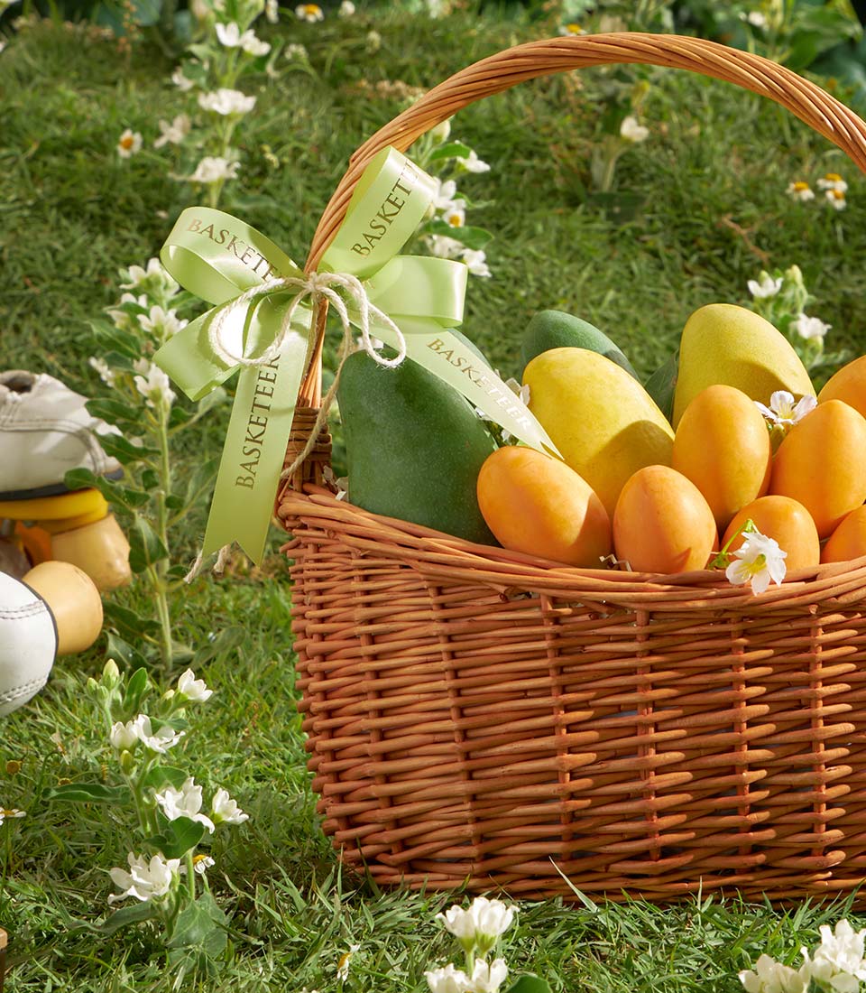 Premium mixed mango and mayongchid tropical fruit gift basket with green wicker and ribbon bow