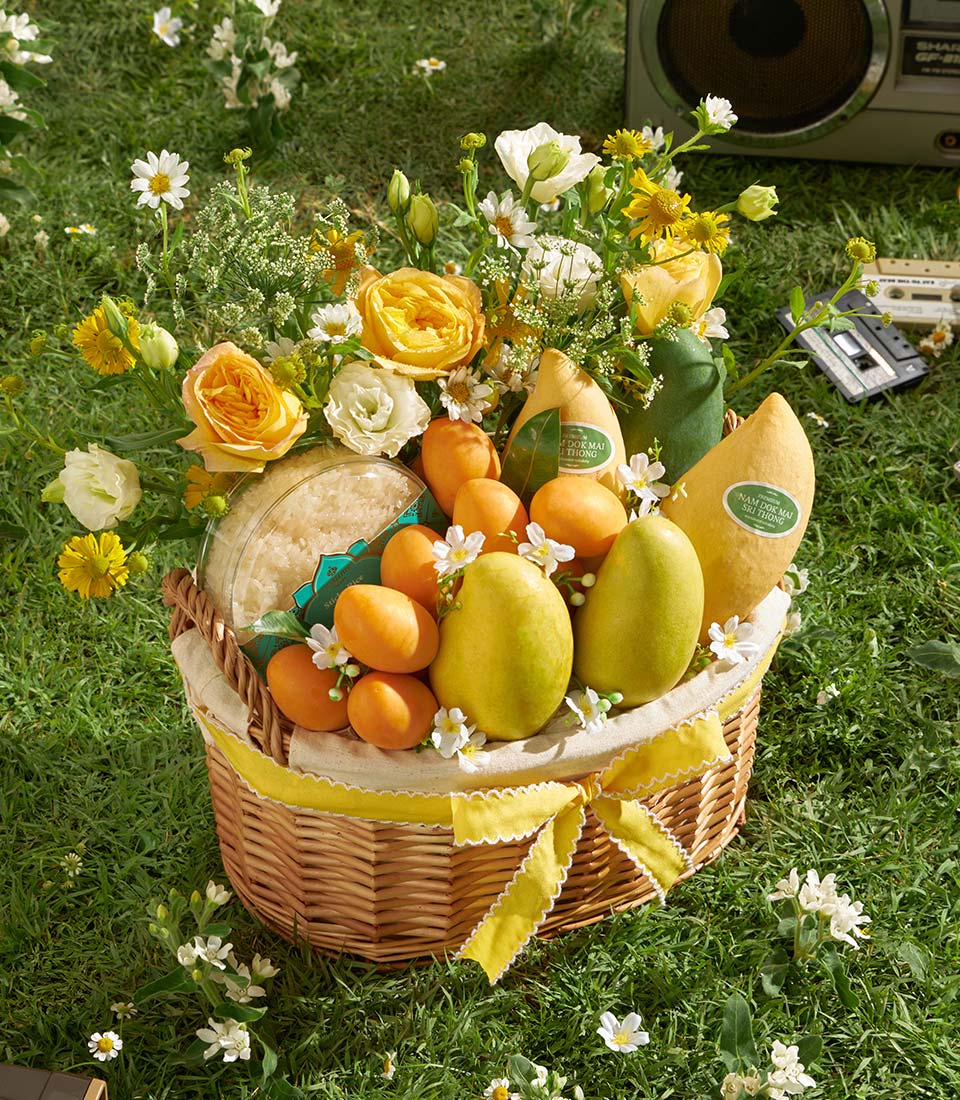 Premium mango and mayongchid gift basket with fresh roses, daisies, and sticky rice in woven wicker with yellow ribbon