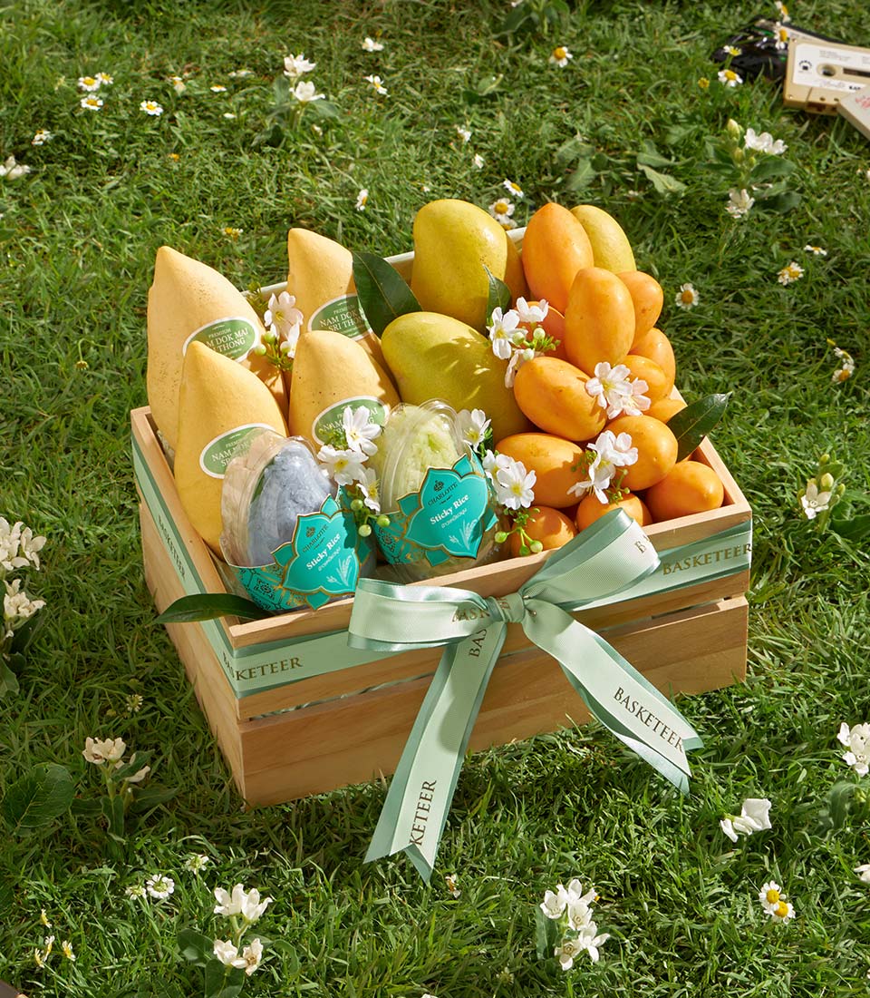 Wooden crate gift hamper with Nam Doc Mai mangoes, tropical fruits, and sticky rice in blue and green